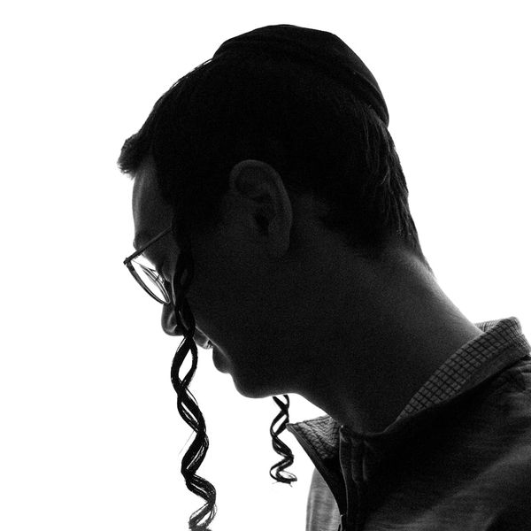 Silhouette of a man in a meditative pose against a dark background.